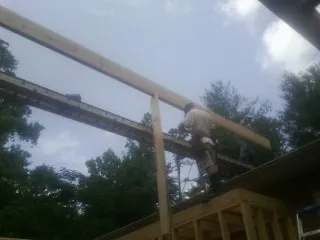 Carpenter setting a ridge beam over a new addition frame — Ice Dam Removal by Roofing Brothers in Fountain City