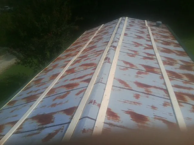 Rusted metal roof panels with new wood purlins before replacement — Storm Damage Roof Repair in Fountain City by Roofing Brothers