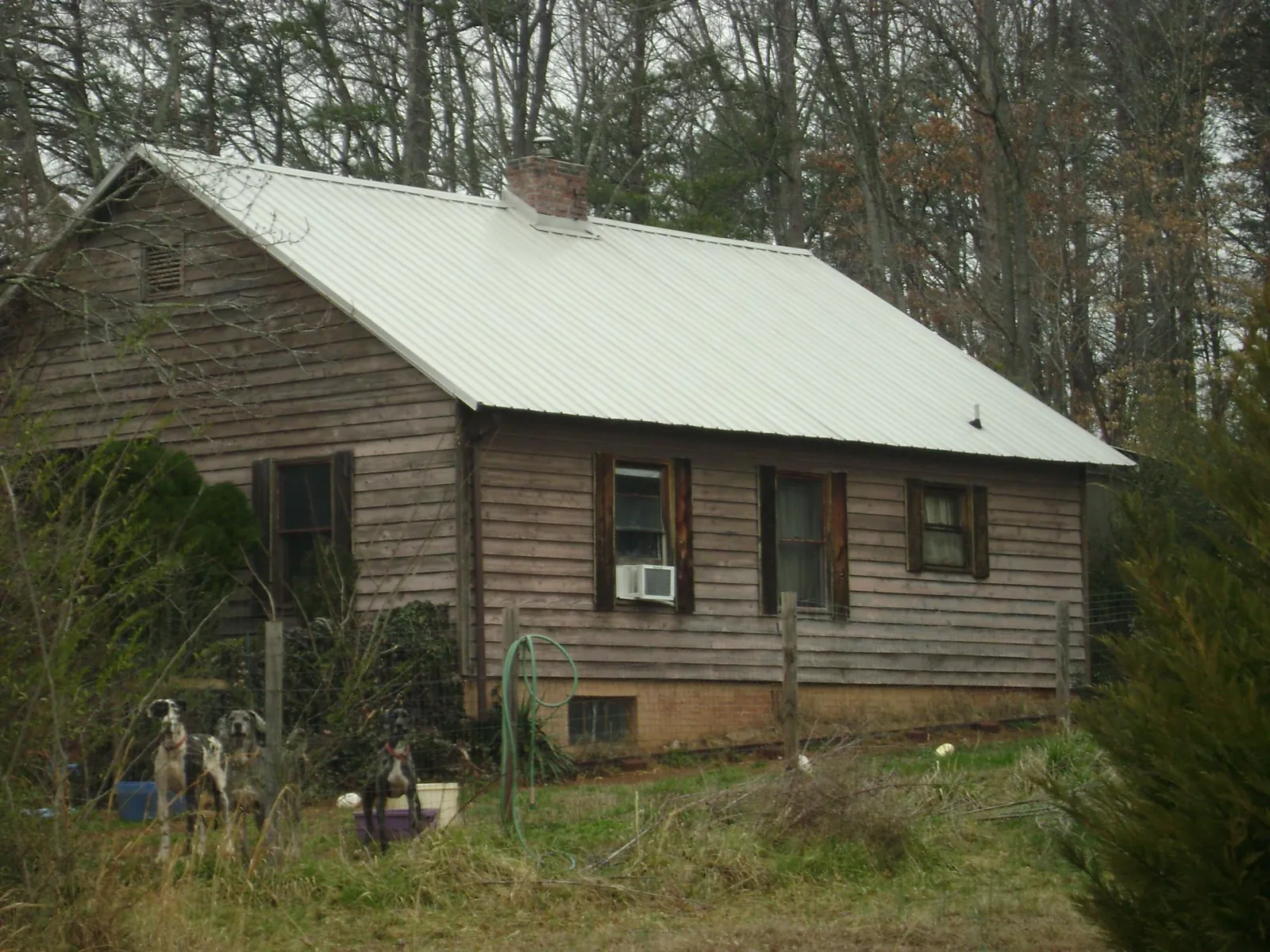 White metal roof on an old wood sided farmhouse, from a Metal Roof Installation job in Fountain City